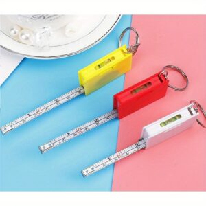 Kompaktna čelična merna traka dužine jedan metar, prenosiva, sa privezkom za ključeve i horizontalnim kvadratnim dizajnom napravljenom od plastike.